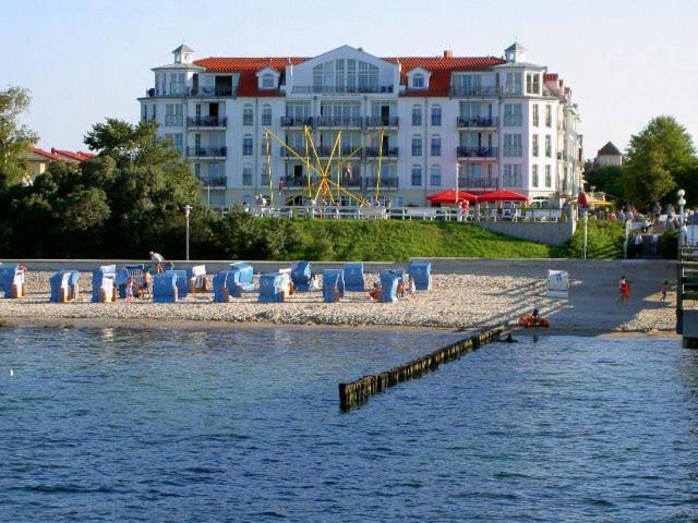 una playa con sillas y un edificio de fondo en Apartmenthaus Atlantik en Kühlungsborn