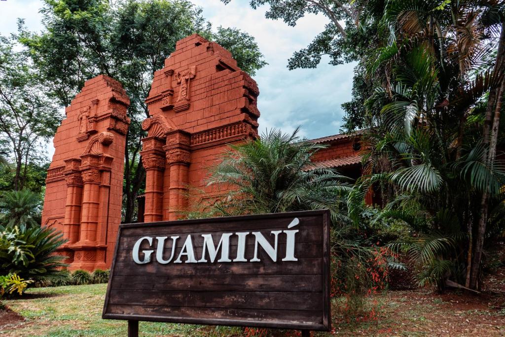 un cartello di fronte a un edificio di mattoni rossi di Hotel Guaminí Misión a Puerto Iguazú