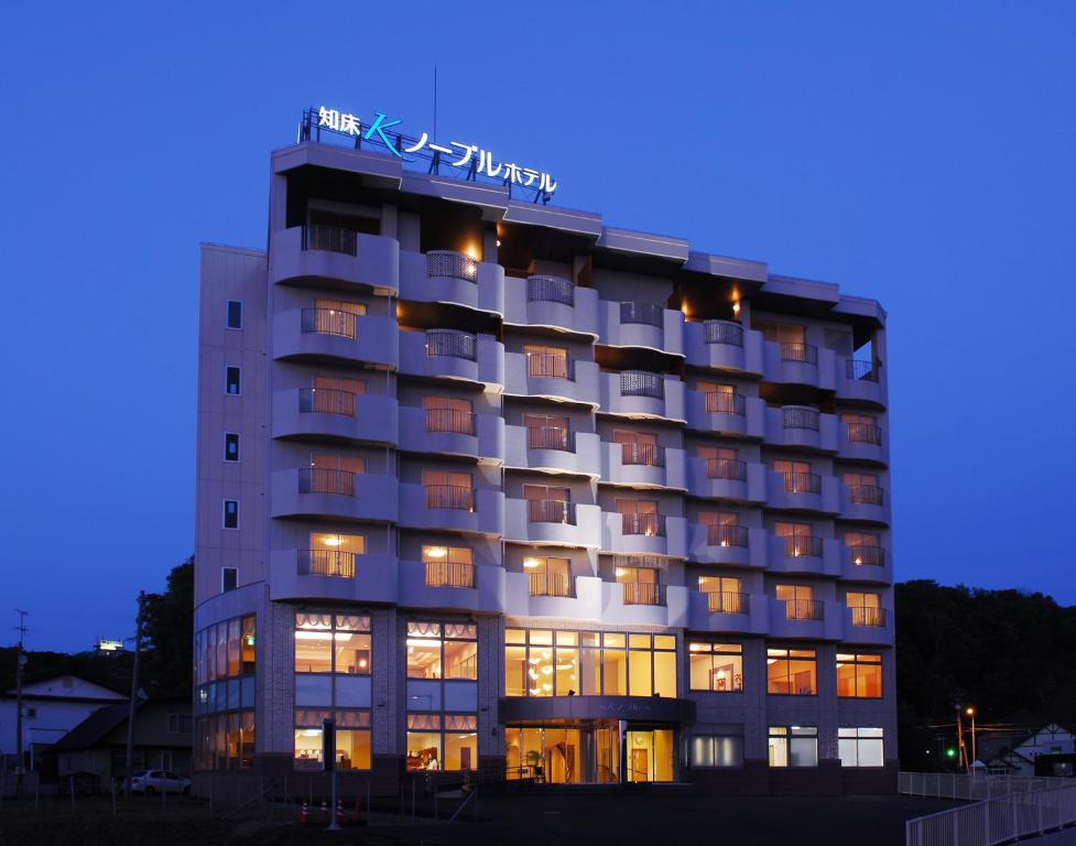 un bâtiment d'hôtel avec un panneau en haut dans l'établissement Shiretoko Noble Hotel, à Shari