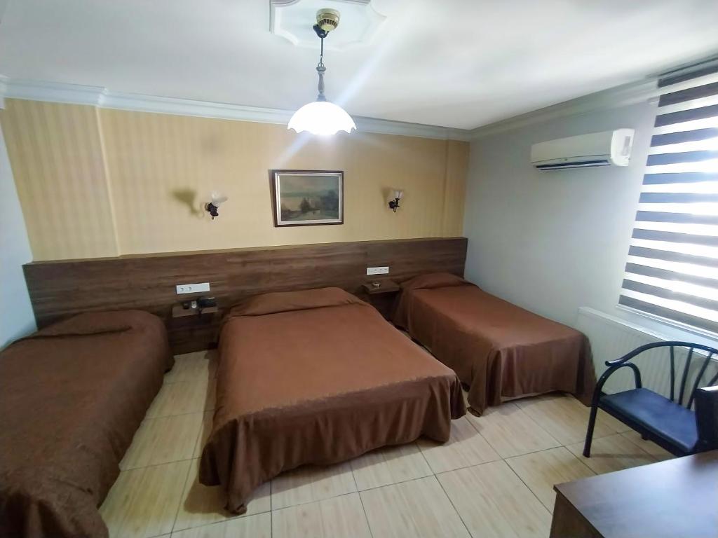 um quarto com duas camas e uma mesa em Yunus Hotel em Gaziantep