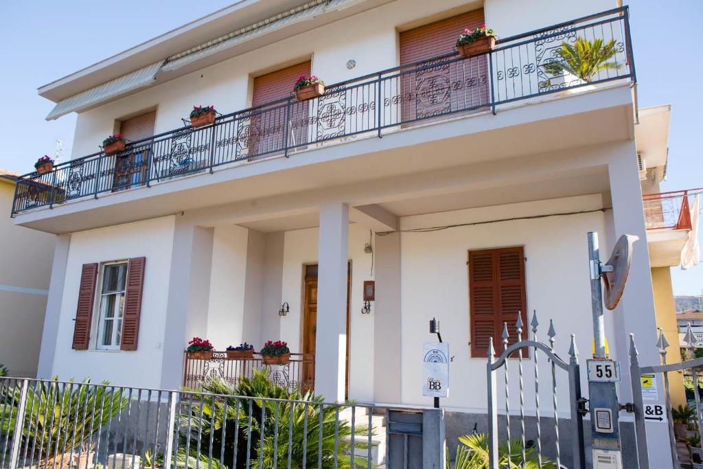 ein weißes Haus mit Topfpflanzen auf dem Balkon in der Unterkunft B&B Pescara Airport in San Giovanni Teatino