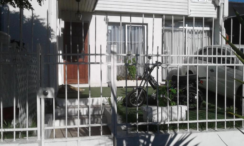 Una bicicleta en una valla delante de una casa en Alojamiento en Chillán en Chillán