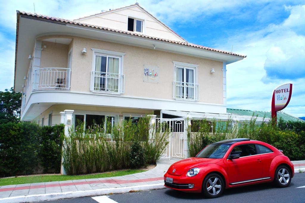 a red car parked in front of a house at Hotel Hola in Florianópolis