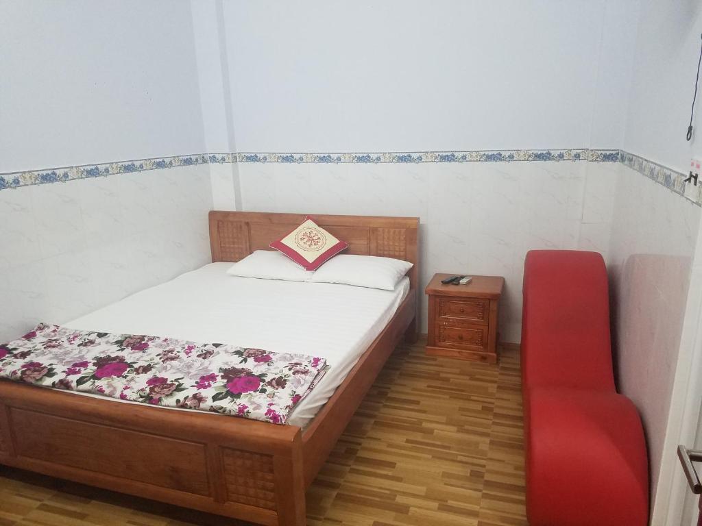 um quarto com uma cama e uma cadeira vermelha em MyDungmotel em Da Nang