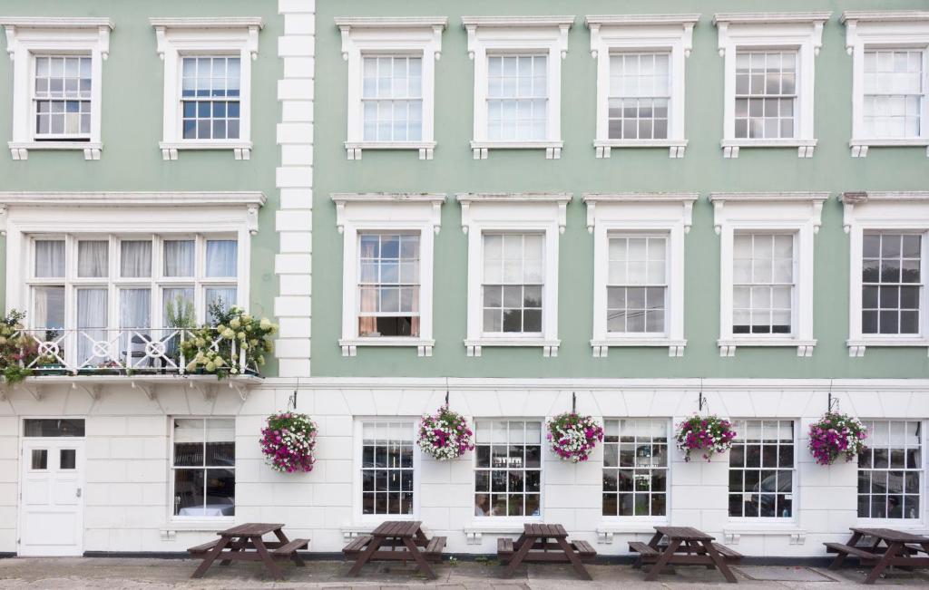 un edificio con mesas de picnic delante de él en The Clarendon Royal Hotel en Gravesend