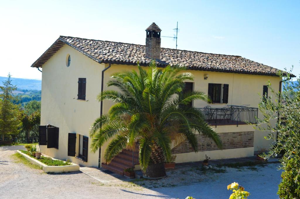 een huis met een palmboom ervoor bij Cardinal Girolamo in Montefalco