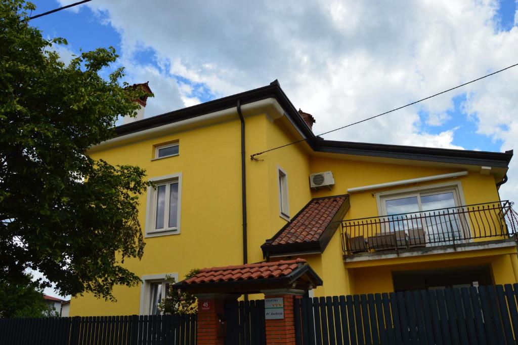 a yellow house with a fence in front of it at Apartment Kancler in Nova Gorica