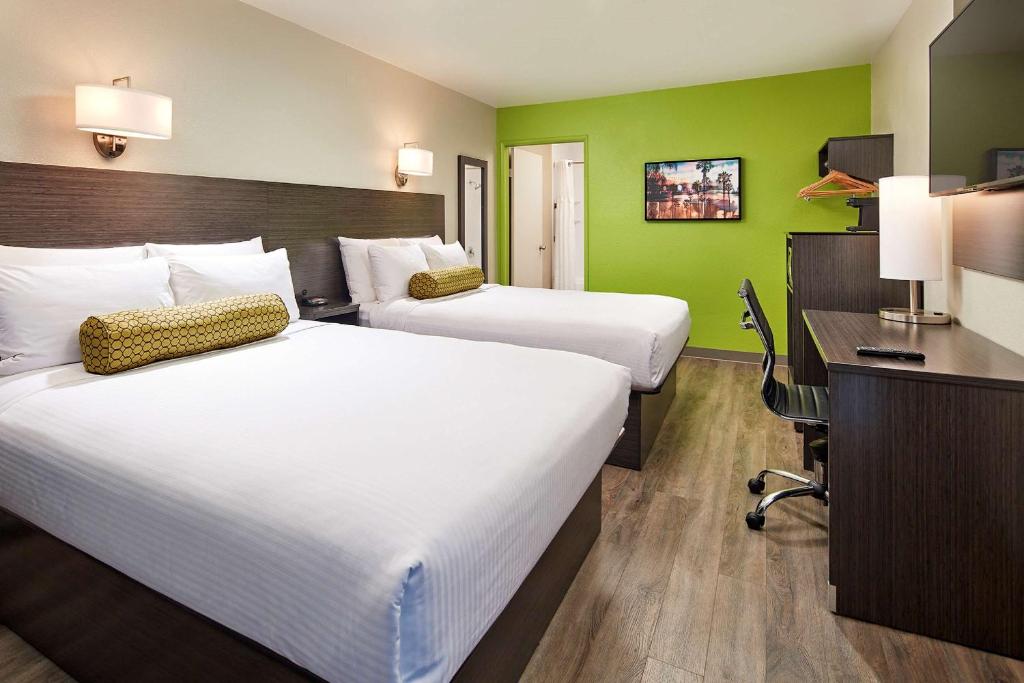 twee bedden in een hotelkamer met groene muren bij SureStay Hotel by Best Western San Diego Pacific Beach in San Diego