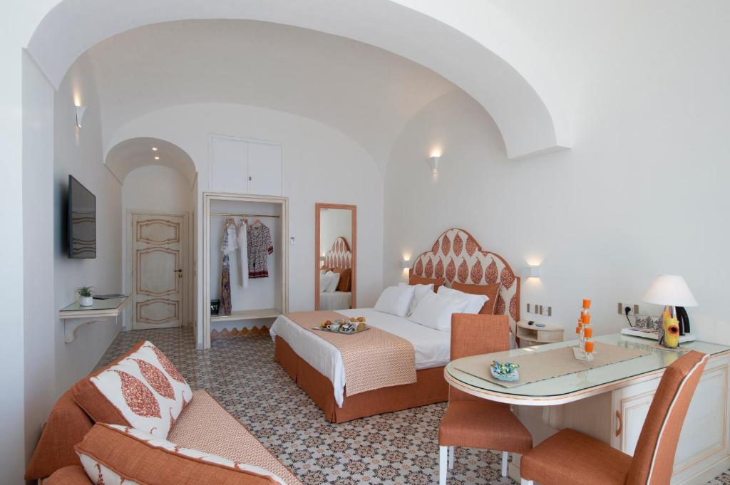 Habitación de hotel con cama, mesa y sillas en CASA CAPRILE POSITANO en Positano