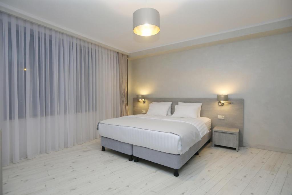 a bedroom with a large white bed in a room at Sunset Terrace Mestia in Mestia