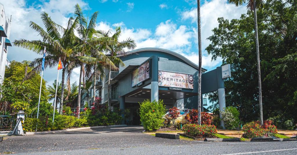 un edificio al lado de una calle con palmeras en Heritage Cairns Hotel en Cairns