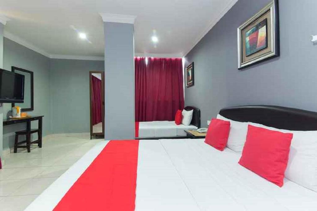 - une chambre dotée d'un grand lit avec des oreillers rouges et blancs dans l'établissement Puteri Ampang Hotel, à Ampang