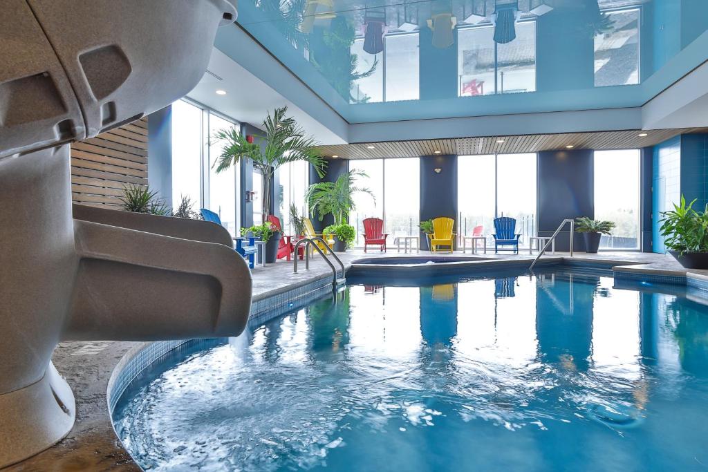 - une grande piscine dans un bâtiment doté de fenêtres dans l'établissement Comfort Inn & Suites, à Saint-Jérôme