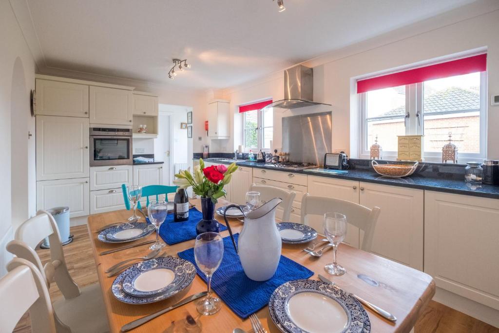 una cocina con una mesa de madera con un jarrón. en April Cottage en Aldeburgh