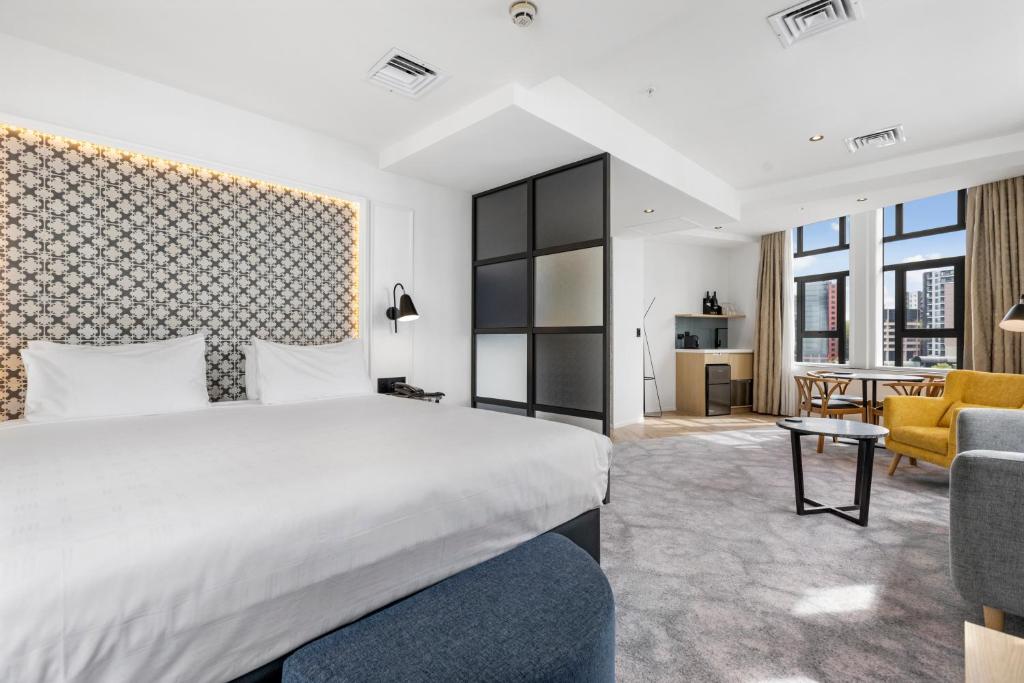 een slaapkamer met een bed en een woonkamer bij Airedale Boutique Suites in Auckland