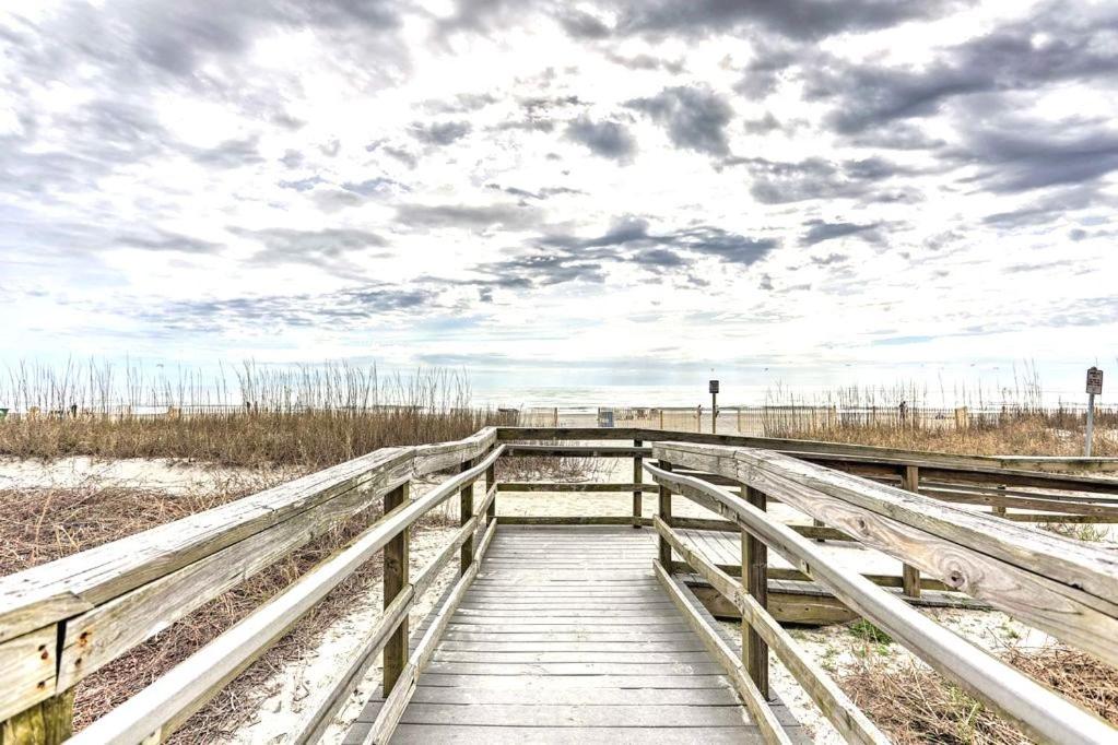 un ponte di legno sulla spiaggia con un cielo nuvoloso di Ocean Front, Private Balconies a Myrtle Beach