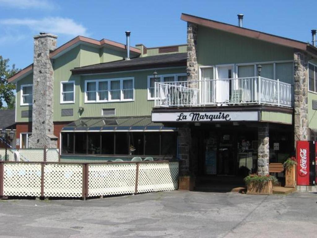 ein großes Gebäude mit einem Restaurant mit Balkon in der Unterkunft Hotel Motel La Marquise in Sherbrooke