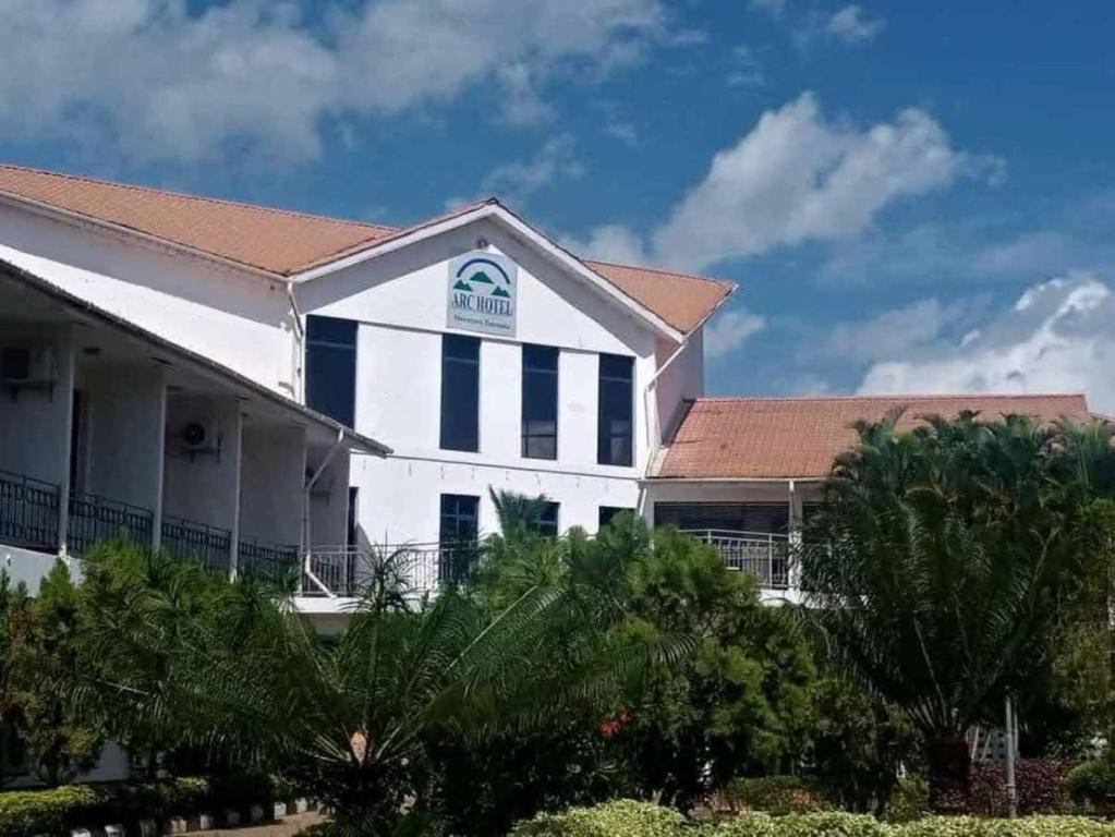 een wit gebouw met een rood dak bij Arc Hotel in Morogoro