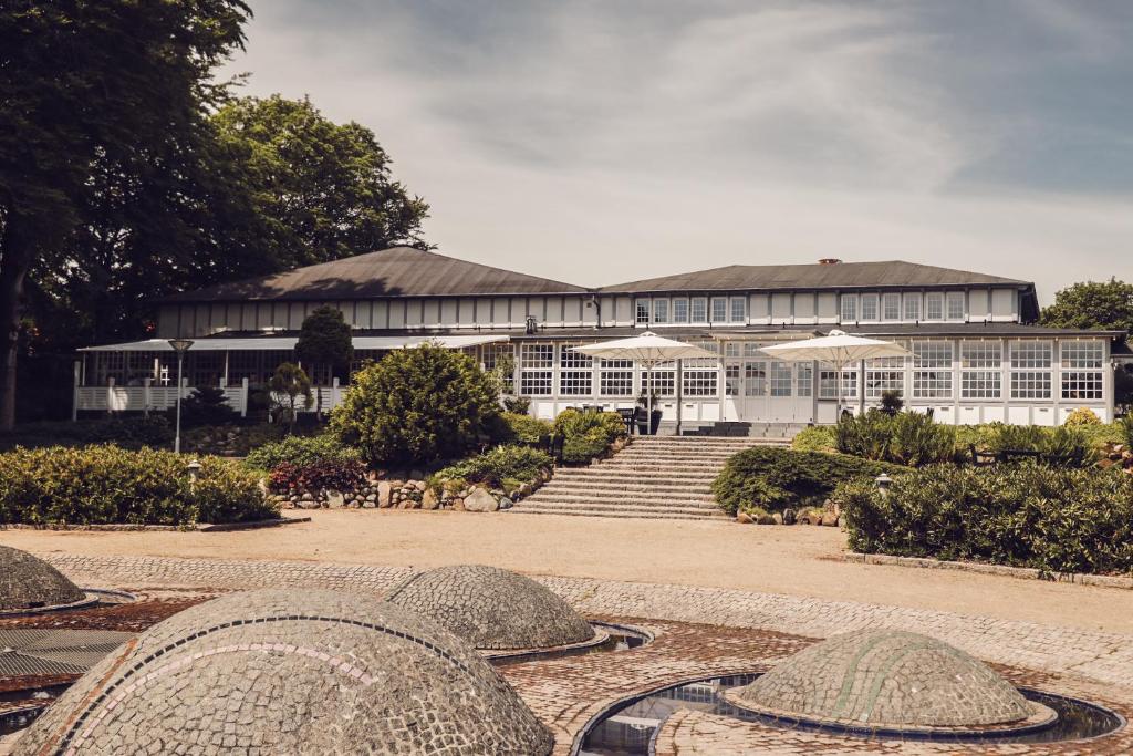 un bâtiment avec des escaliers et des parasols en face de celui-ci dans l'établissement Arnbjerg Pavillonen, à Varde