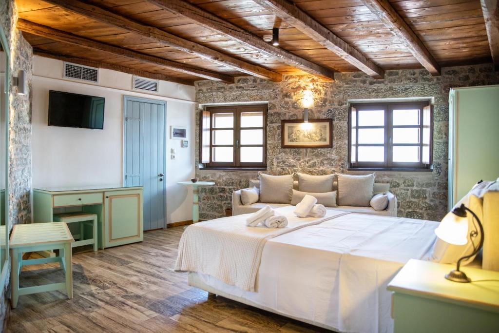 um quarto com uma grande cama branca num quarto em Trapela Areopolis, Boutique Hotel em Areopoli