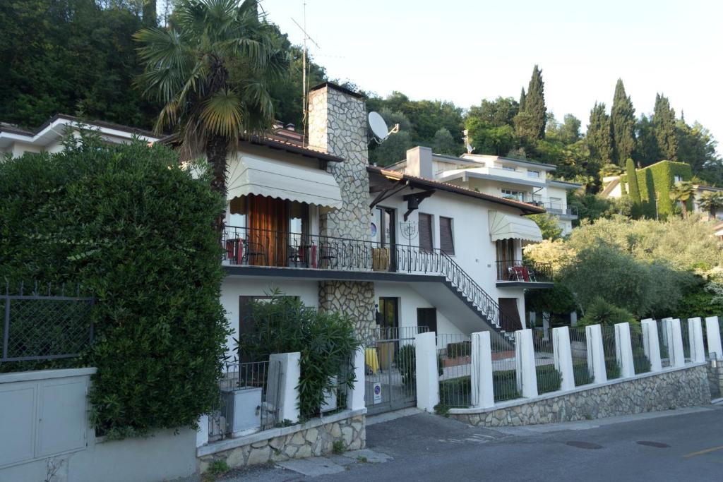 ein weißes Haus mit einem Zaun davor in der Unterkunft Guest House Villa de Ros in Salò