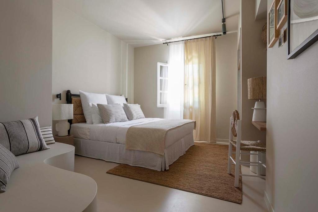 Habitación blanca con cama y sofá en Yayaki Spetses, en Spetses