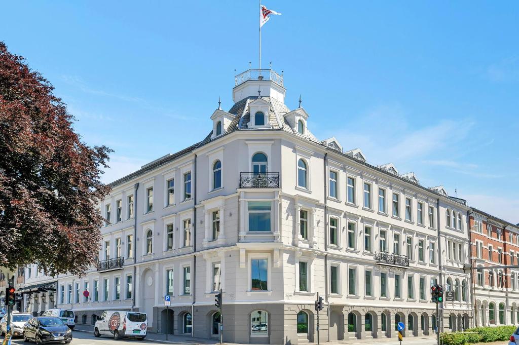 un edificio blanco con una bandera encima en Clarion Hotel Ernst en Kristiansand