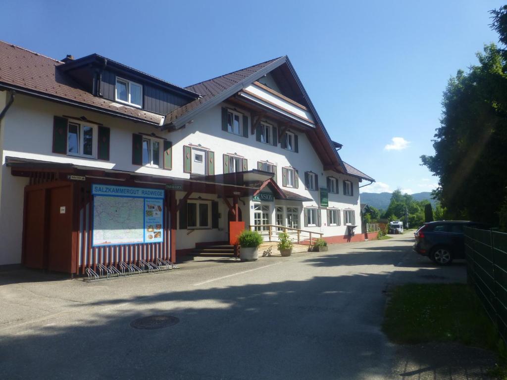 um grande edifício branco com uma placa em frente em ROSSLWIRT-Rast em Strass im Attergau