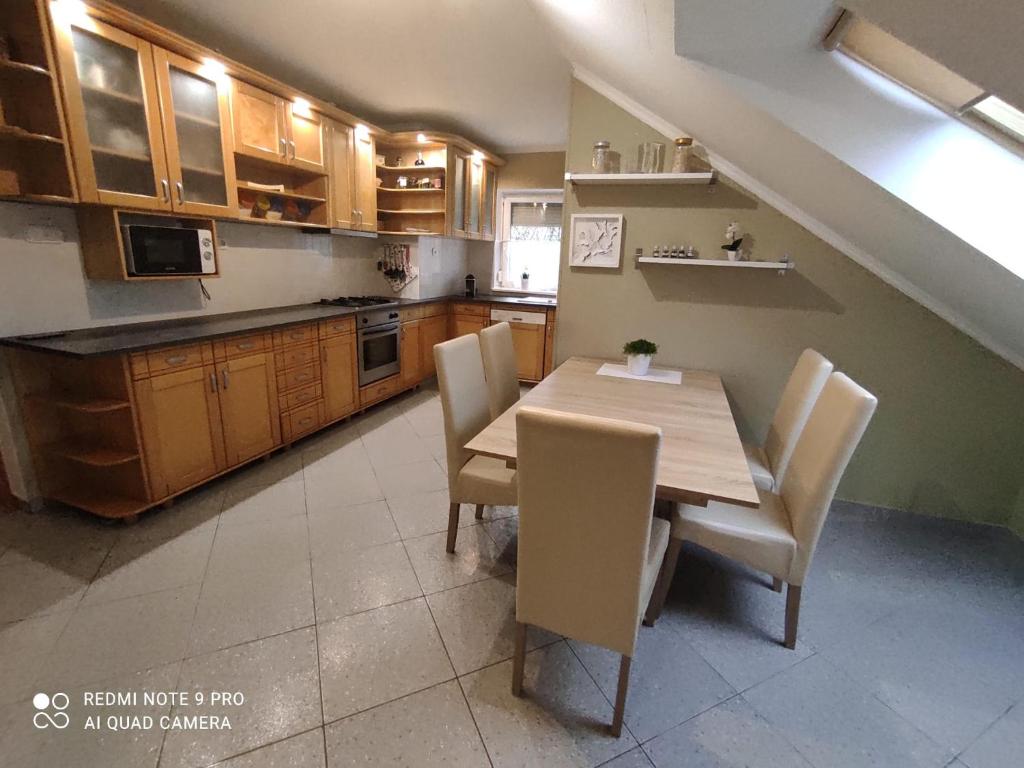 cocina con mesa de madera y sillas en Felhő Apartman, en Balatonfüred