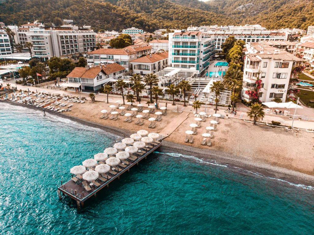 uma vista aérea de uma praia com guarda-sóis e um cais em Emre Beach & Emre Hotel em Marmaris