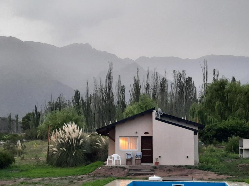 盧漢德庫約的住宿－Starry Lodge，一座白色的小房子,后面是群山