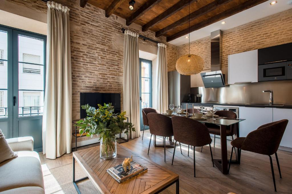 cocina y sala de estar con mesa y sillas en La Sillería de Triana by Magno Apartments en Sevilla