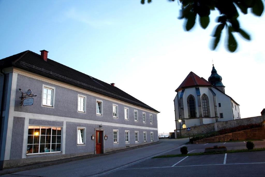 un edificio con una torre dell'orologio accanto a una strada di Gasthof Alpenblick ad Amstetten