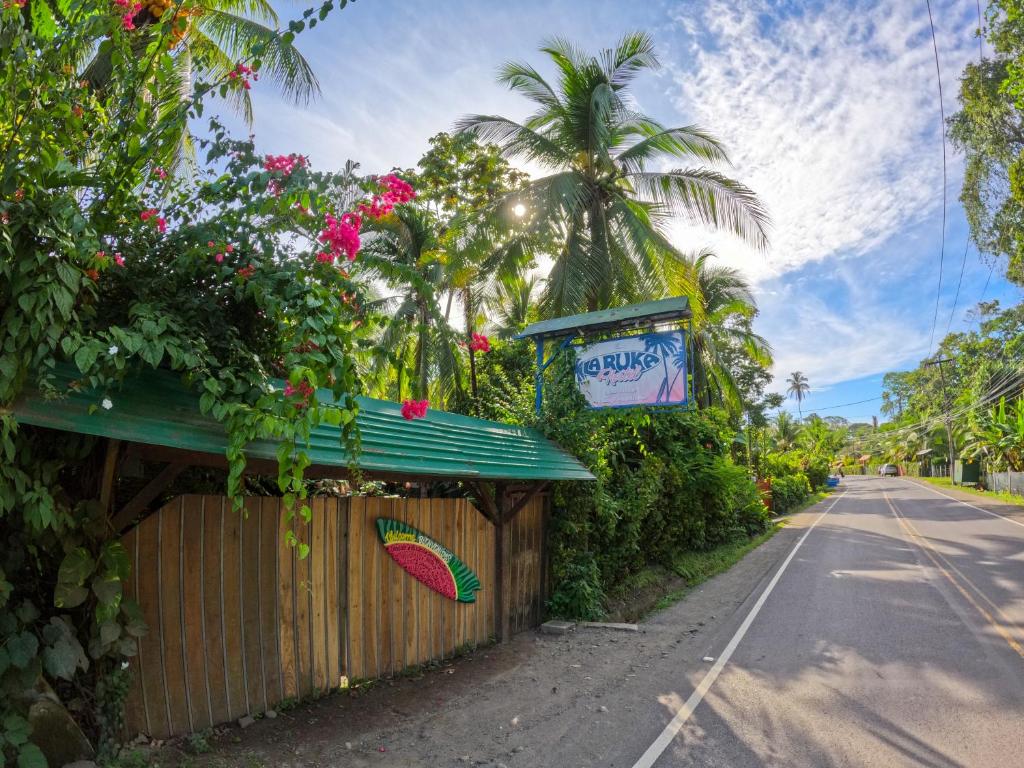 un edificio con un letrero al lado de una carretera en La Ruka Hostel en Puerto Viejo