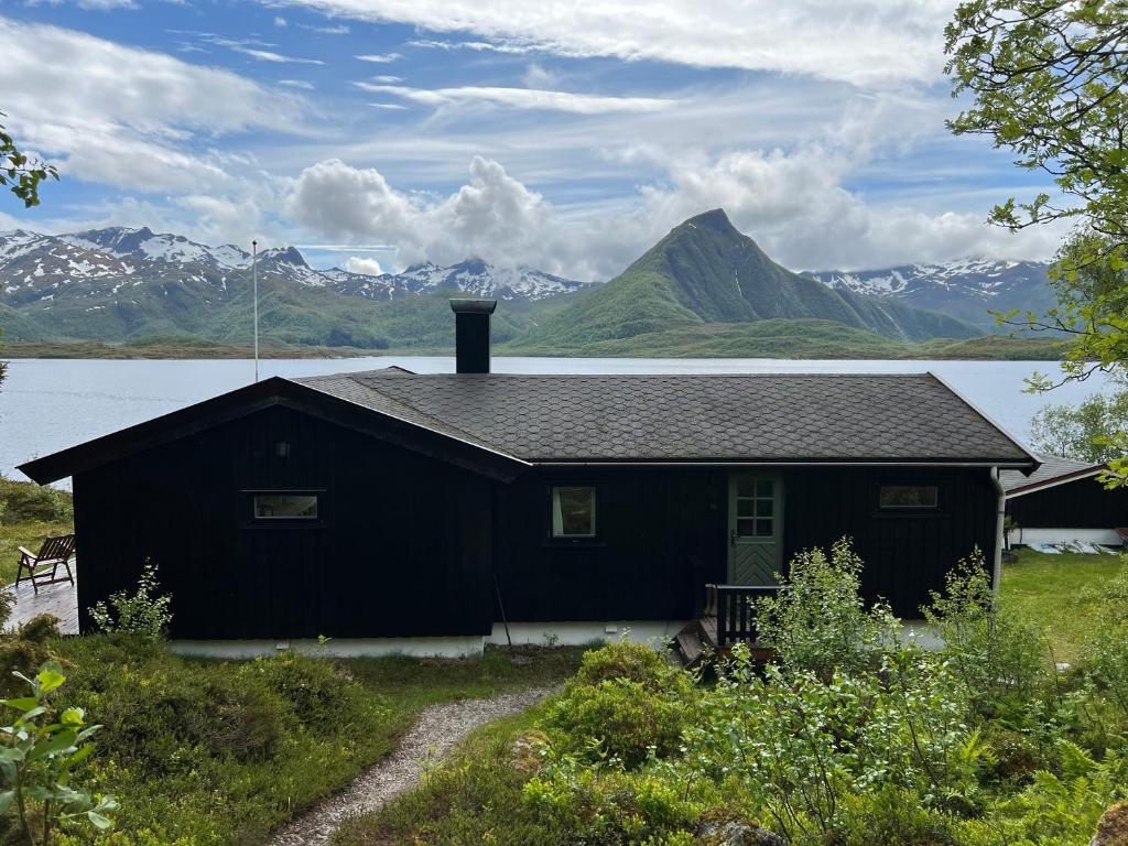 SandslettaにあるLofoten Midnight Sun Lodgeの山を背景にする黒家