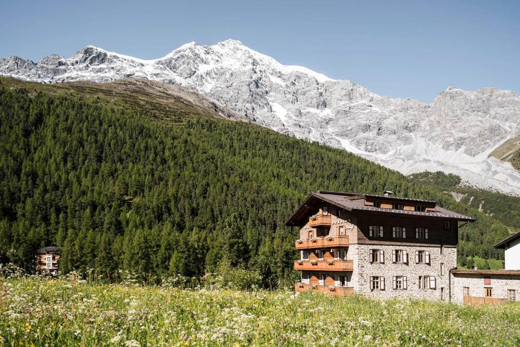 un edificio en una colina con montañas en el fondo en Glacier Rock guesthouse en Solda