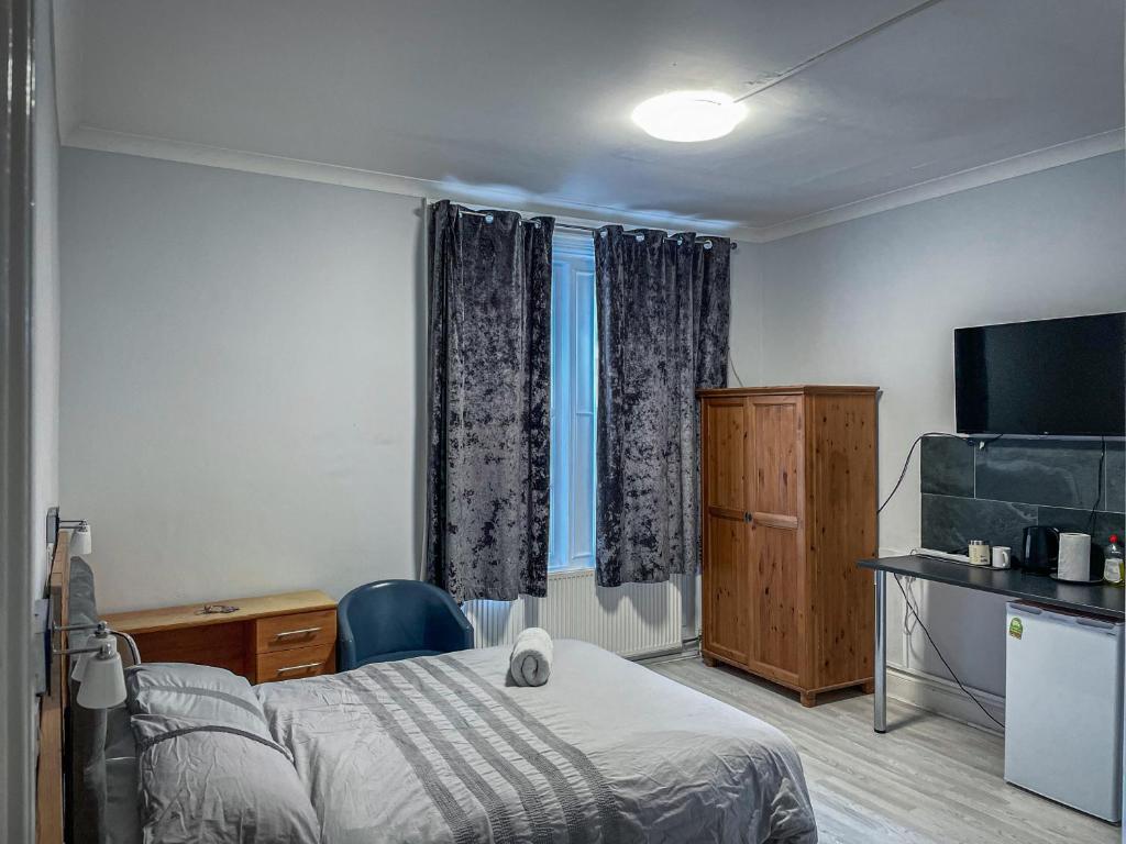 une chambre d'hôtel avec un lit et une télévision dans l'établissement The New George Hotel, à Newcastle upon Tyne