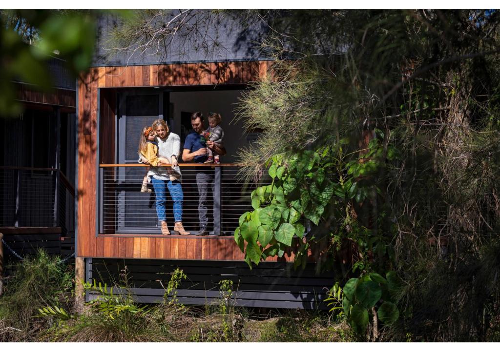 un grupo de personas de pie en un balcón de una casa en Discovery Parks - Byron Bay, en Byron Bay