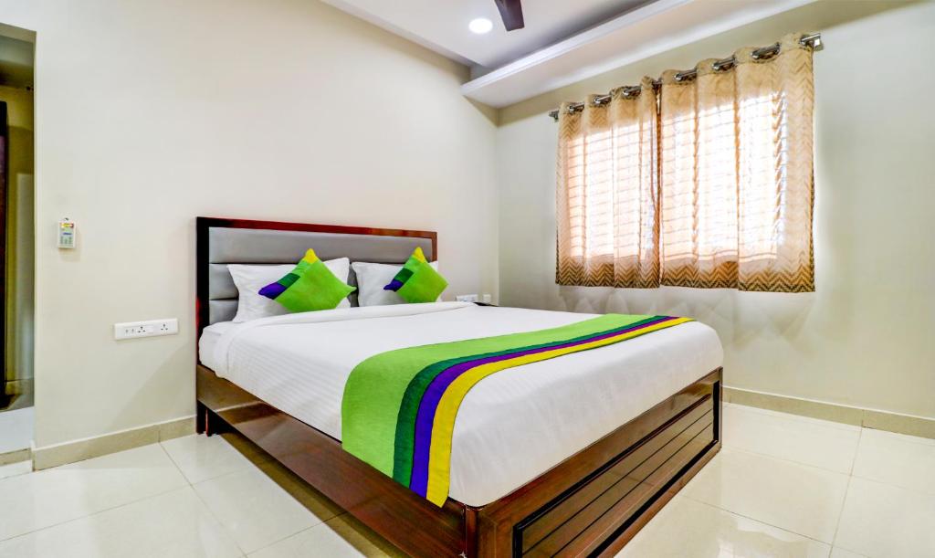 - une chambre avec un grand lit et une couverture colorée dans l'établissement Treebo Grand Milan, à Visakhapatnam