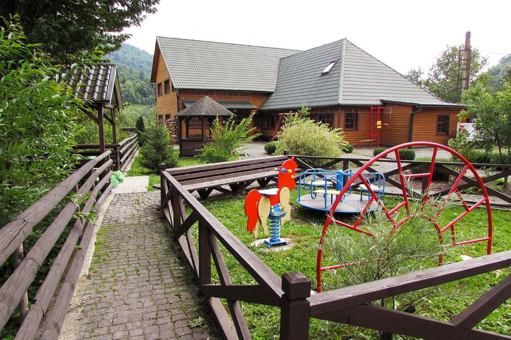 un parque infantil en un patio con una casa en Шале На бе́резі, en Kvasy