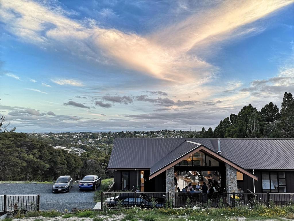 twee auto's geparkeerd op een parkeerplaats naast een huis bij Echo Lodge in Auckland