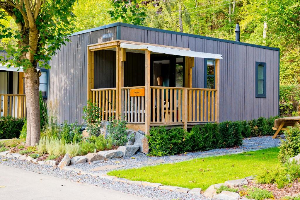 una casa pequeña con porche en un jardín en Chalet Fuusslee en Goebelsmuhle