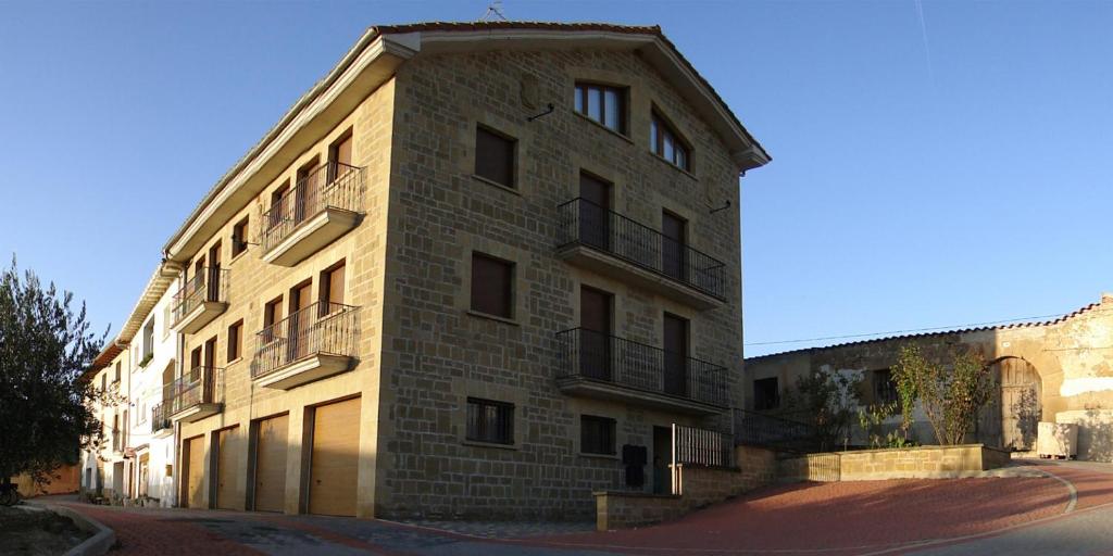 un gran edificio de ladrillo en una calle de la ciudad en Apartamentos Eneriz en Enériz