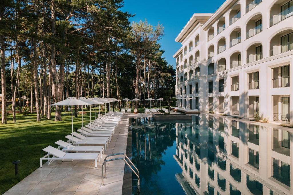 una piscina de hotel con sillas y sombrillas junto a un edificio en Ensana Aquahouse en St. St. Constantine and Helena