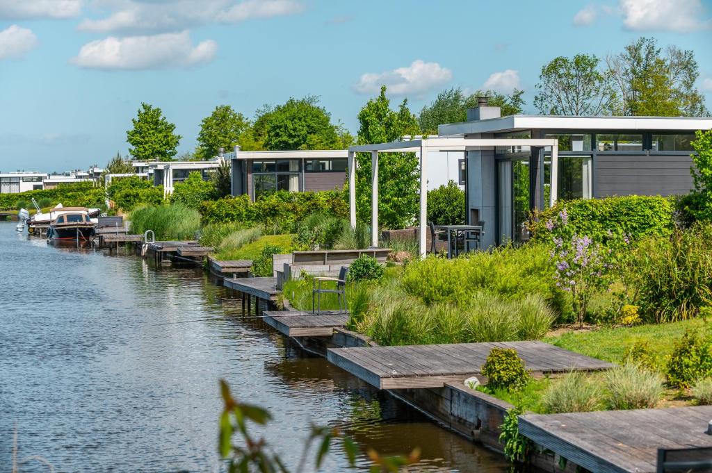 ein Gebäude neben einem Fluss mit einem Dock in der Unterkunft EuroParcs Veluwemeer in Nunspeet