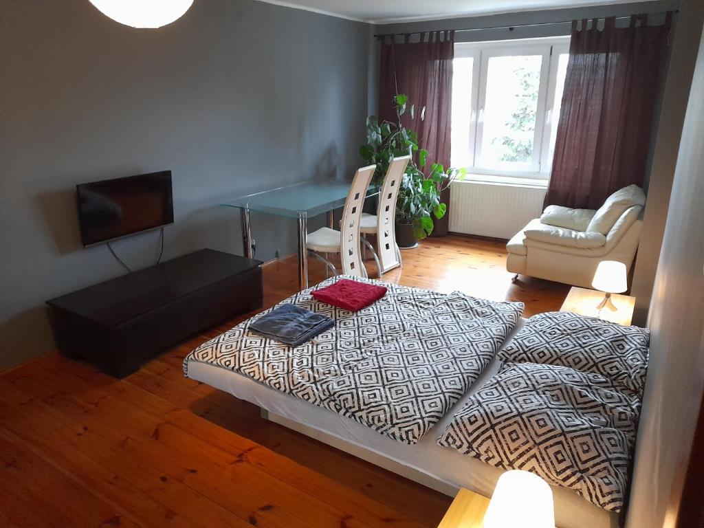 uma cama numa sala de estar com uma mesa e um sofá em Villa Kornelka em Poznań