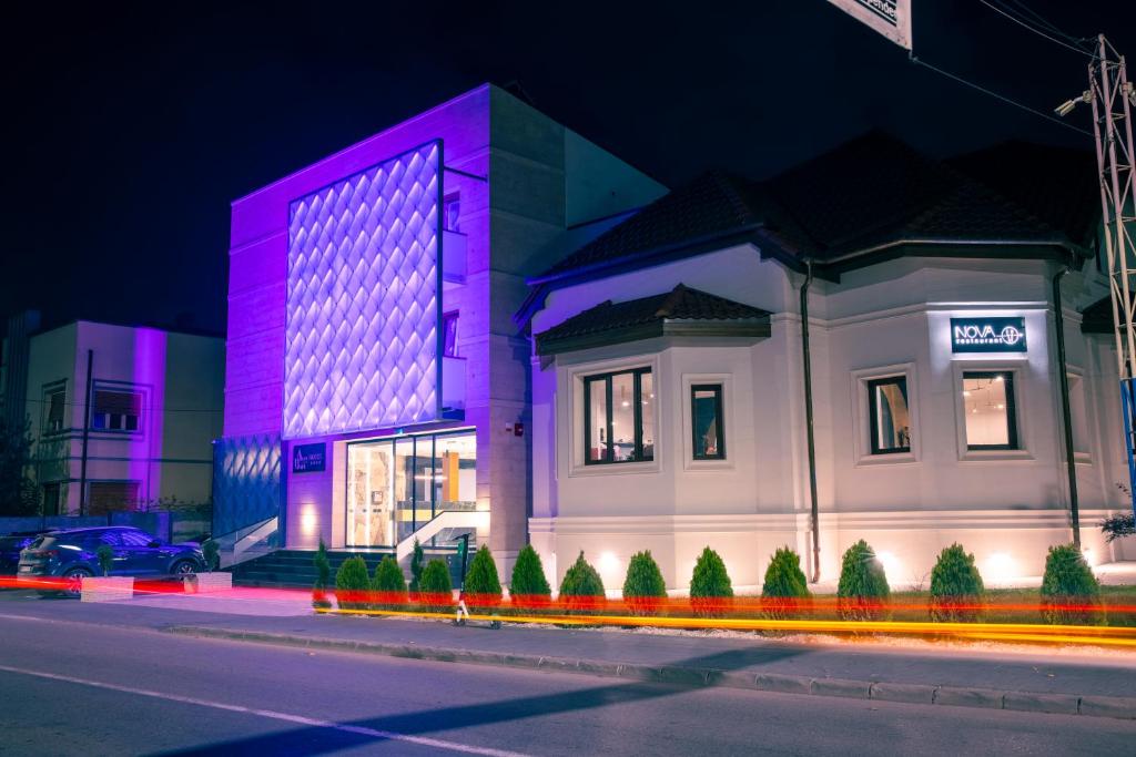 een gebouw dat is verlicht in het paars bij Hotel Aura Unirii in Alba Iulia