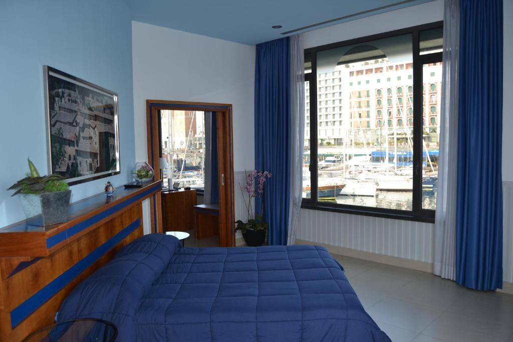 1 dormitorio con cama azul y ventana grande en Transatlantico, en Nápoles