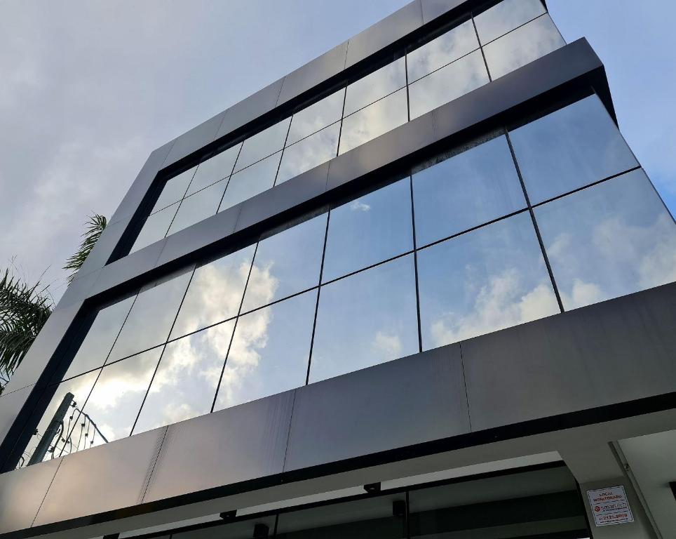 un edificio de cristal con el cielo reflejado en sus ventanas en Seasons BC, en Balneário Camboriú