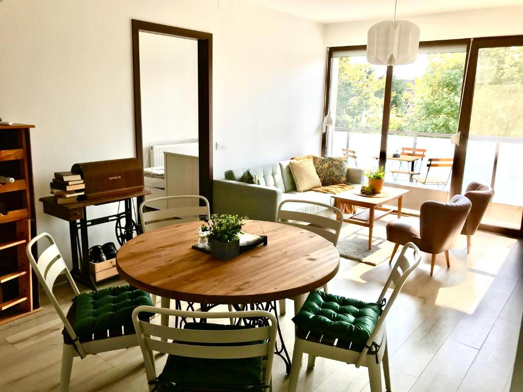 ein Wohnzimmer mit einem Tisch und Stühlen in der Unterkunft Erkel 19 Apartmanház in Keszthely